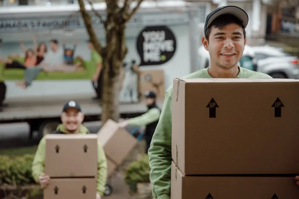 smiling mover carrying boxes